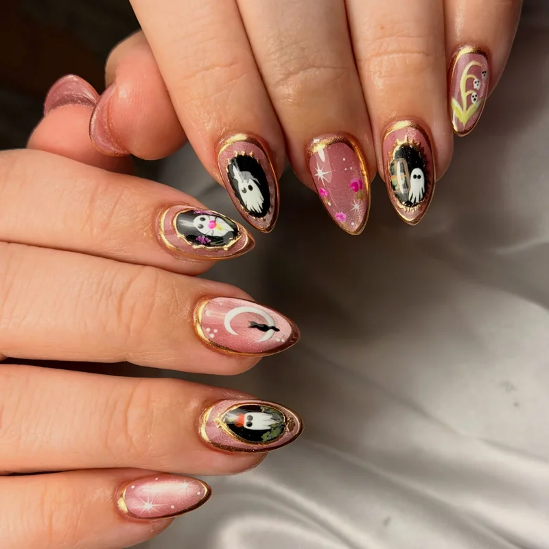 Pink almond nails with miniature black-and-white portraits, delicate gold borders, and gold star accents.