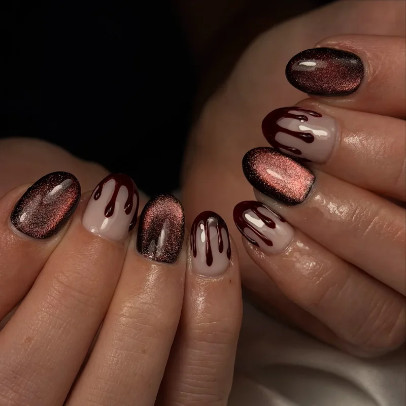Rounded nails alternating copper-brown shimmer and dark chocolate drip designs on a sheer pink base.