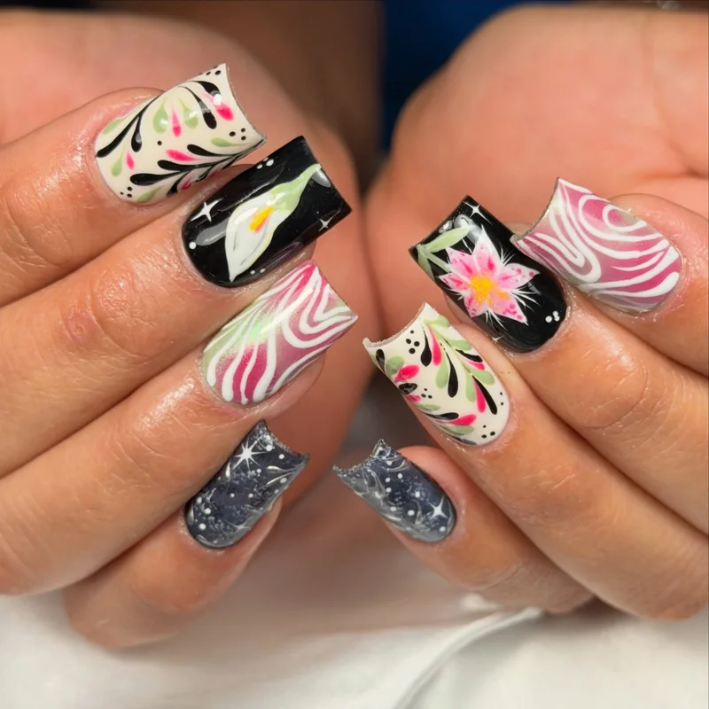 Square nails with pink zebra stripes, small green and pink florals, silver shimmer, and black-and-white accents.
